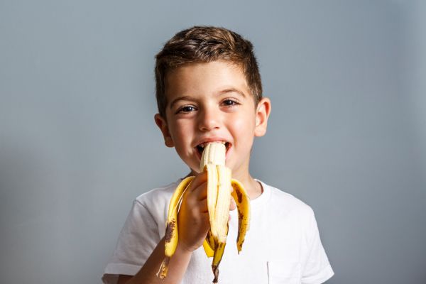 happy child eating a banana 