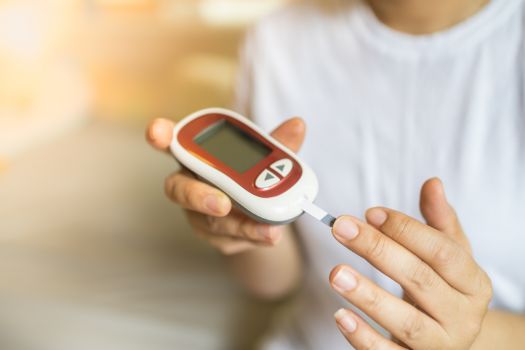 Diabetes patient measures her sugar levels using glucometer 