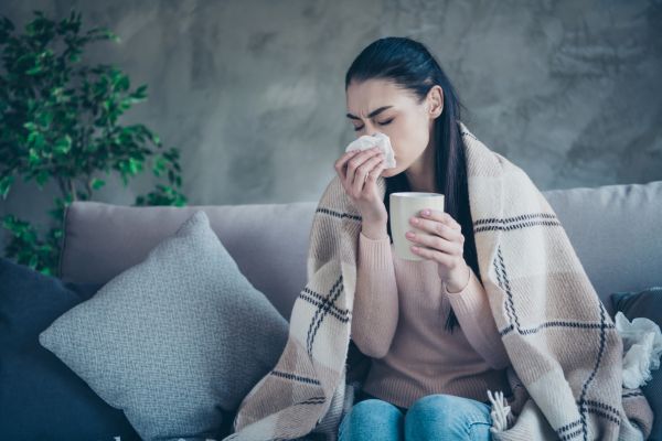 a woman having a cold and a runny nose 