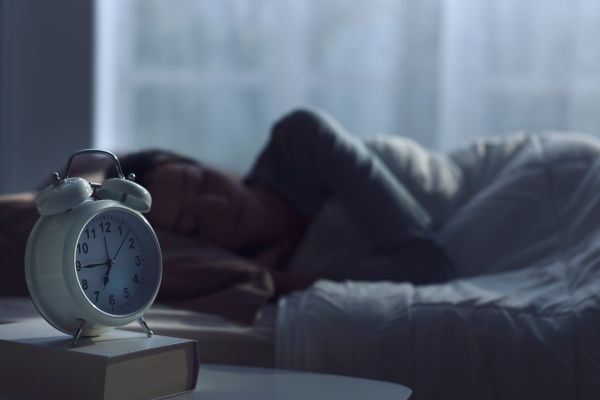 A woman falling in a deep sleep. Alarm clock